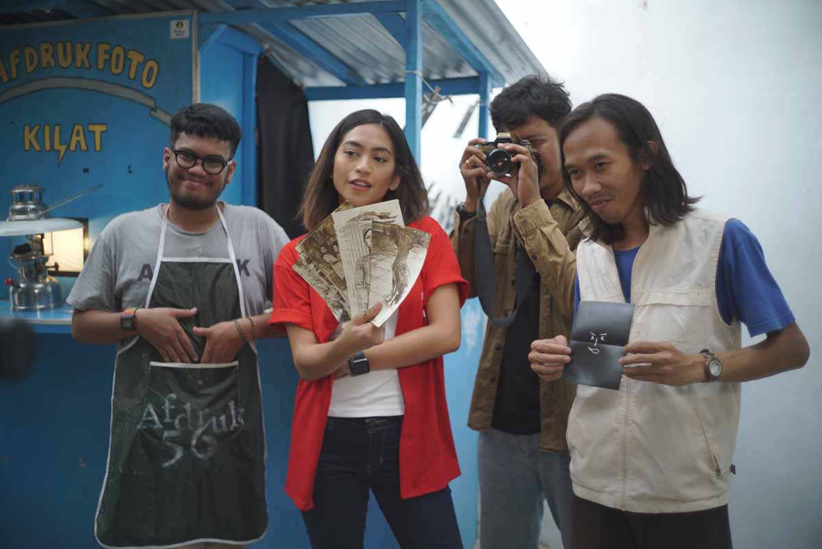 Host MLDSPOT dan anggota Afdruk 56 berfoto dengan memamerkan alat dan hasil dari kamera analog